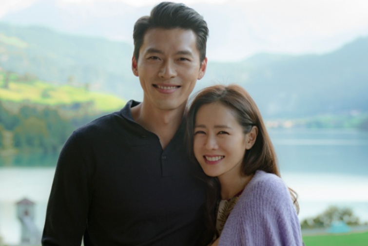 Hyun Bin & Sohn Yejin smiling in front of a beautiful lake