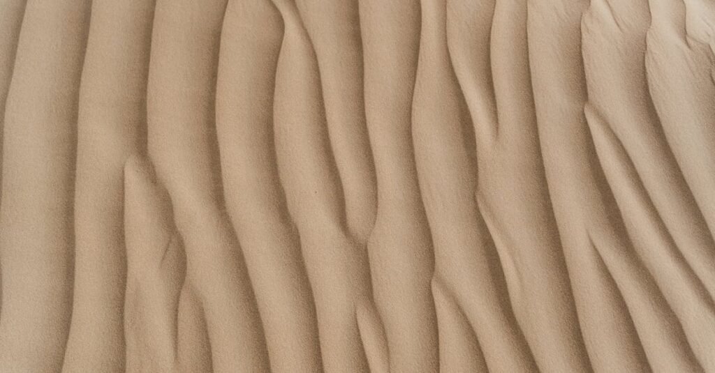 Close-up view of textured sand dunes showcasing natural patterns and arid beauty.